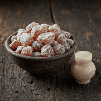 A simple earthenware bowl of handcrafted Nard incense, resting on aged wood next to an ancient, alabaster-style ointment jar.