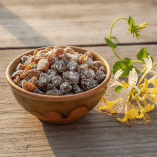 A honey-colored earthenware bowl of handcrafted Honeysuckle incense, resting on a sun-bleached wooden table with a honeysuckle vine.