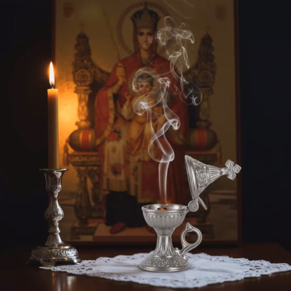 A beautiful silver katzion gently smoking with Marie Antoinette incense, resting on a prayer stand before an icon of the Theotokos, lit by a beeswax candle.